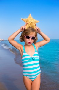 child kid girl in summer beach vacations with starfish